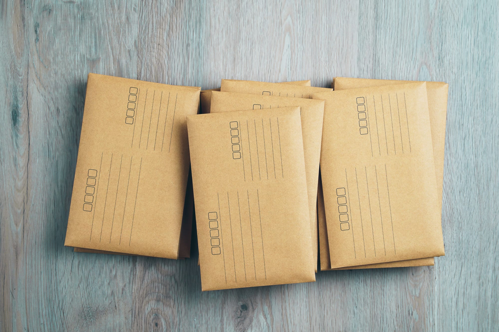 Stacked brown envelopes on wooden background. Stacked brown envelopes on wooden background.